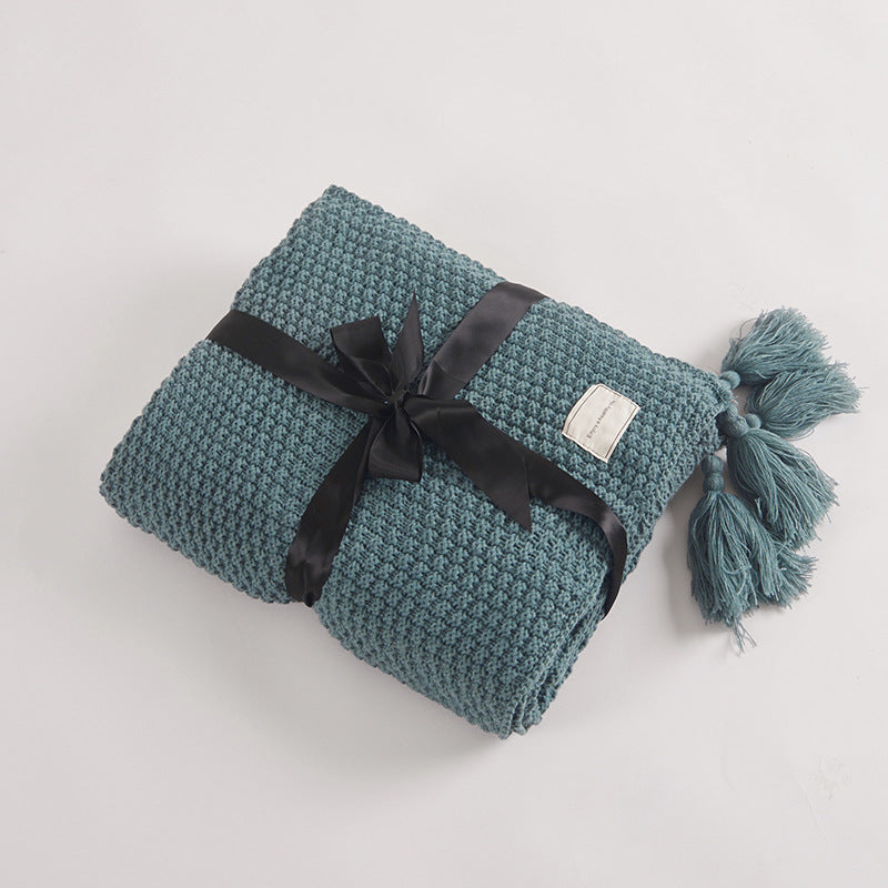 Couverture en maille avec pompons et motifs en relief