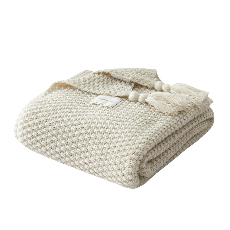 Couverture en maille avec pompons et motifs en relief