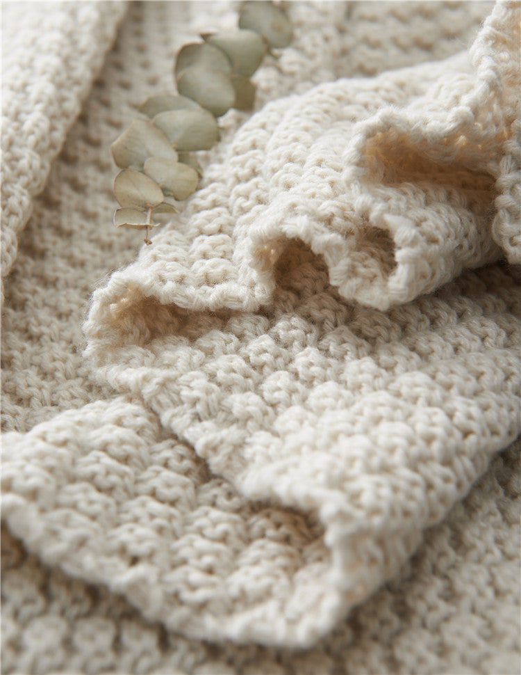 Couverture en maille avec pompons et motifs en relief