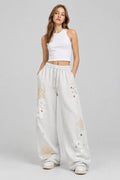 Pantalon de jogging ample  pour femme, style streetwear, coupe large, poches cargo et broderies.